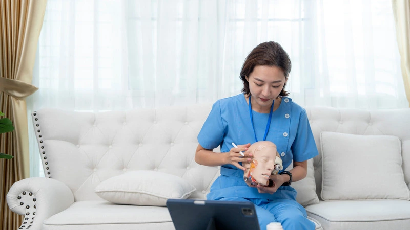 Healthcare professional in scrubs demonstrating anatomical model during online medical training