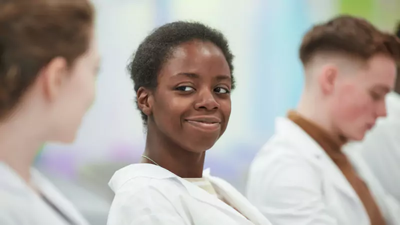 Smiling nurse anesthetist student in medical classroom, representing the educational path to becoming a CRNA