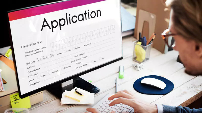 Person filling out an online nursing job application form on desktop computer, preparing for remote nurse employment