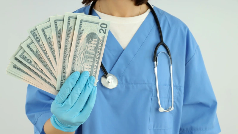 Nurse holding US dollar bills illustrating highest paying nursing jobs