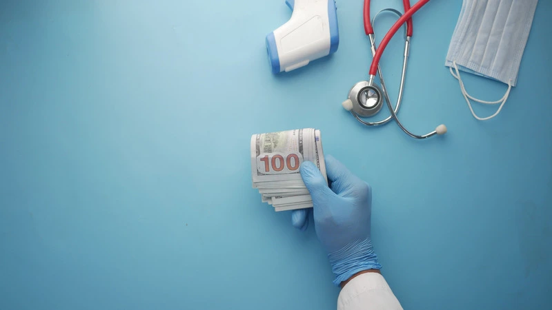 Nurse’s hand in medical glove holding money with stethoscope representing highest paying nursing jobs and salary growth