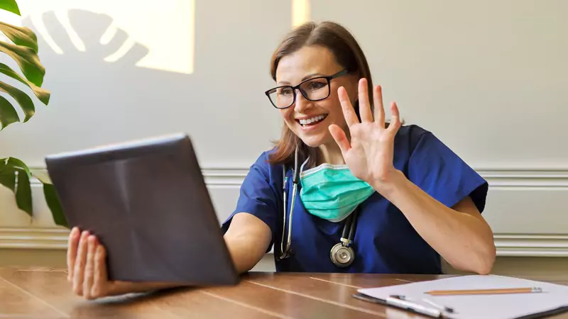 Happy remote nurse conducting virtual patient consultation on tablet, highlighting thriving telehealth roles