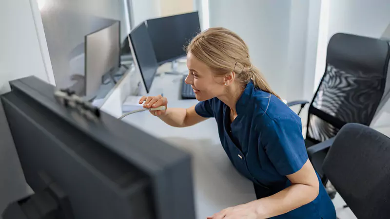Smiling nurse using communication technology demonstrating nursing informatics in healthcare