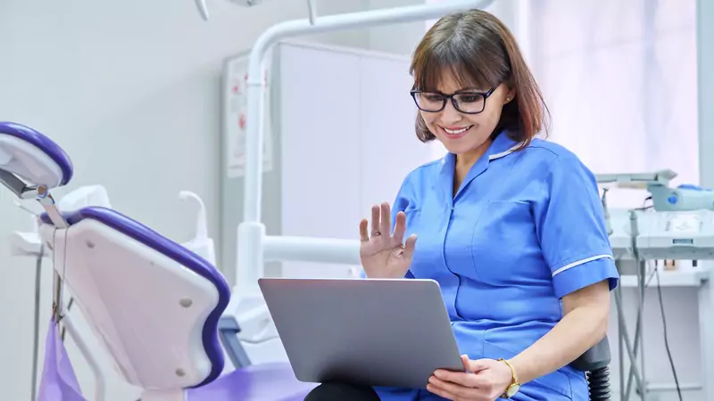 Happy nurse conducting a virtual consultation via laptop, highlighting the benefits of remote nursing positions