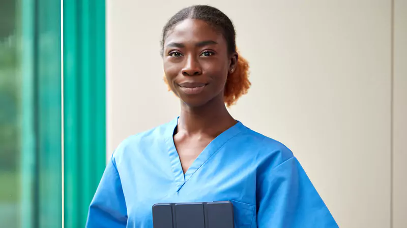 Confident nurse anesthetist holding tablet, representing educational path and certification requirements