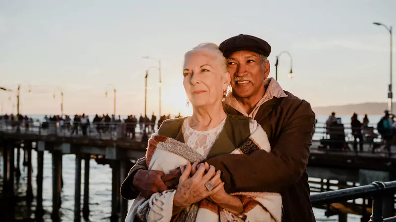 happy-retired-nurse-and-partner-embracing-on-pier-at-sunset-symbolizing-purposeful-post-retirement-life