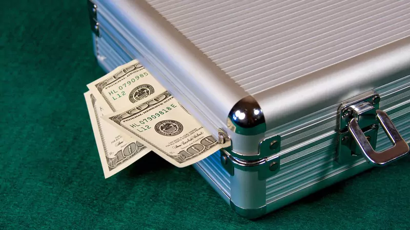 Silver briefcase filled with dollar bills illustrating high travel nurse salary and earning potential