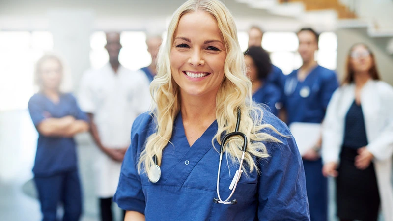 Smiling nurse in hospital setting standing confidently, representing success in highest paying nursing jobs