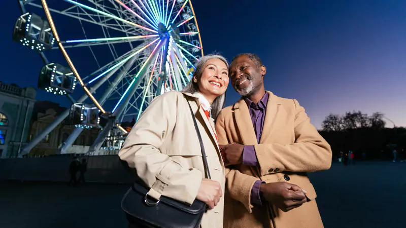 happy-retired-nurse-and-partner-enjoying-leisure-time-by-ferris-wheel