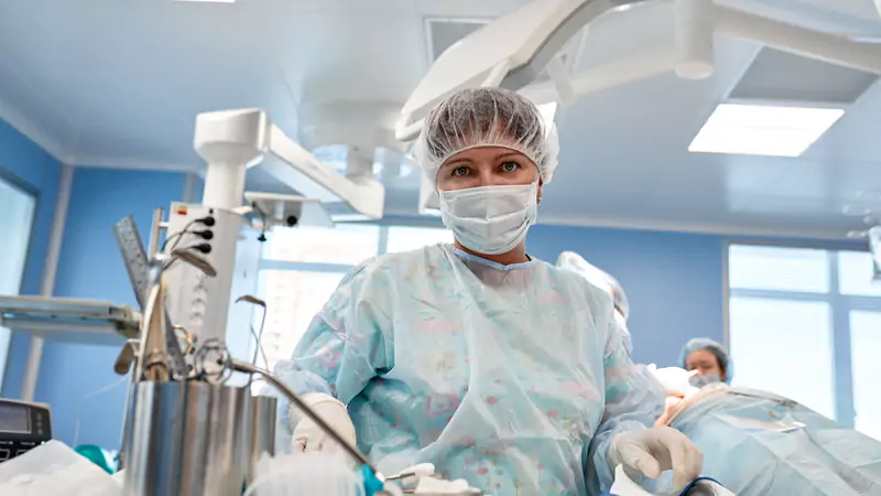 Nurse anesthetist in surgical scrubs preparing for surgery, highlighting precision and impact of CRNA role