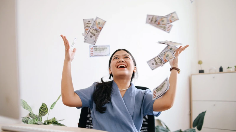 Happy nurse celebrating by throwing money in the air, representing highest paying nursing jobs