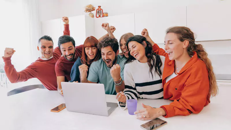 group-of-young-people-celebrating-in-front-of-laptop