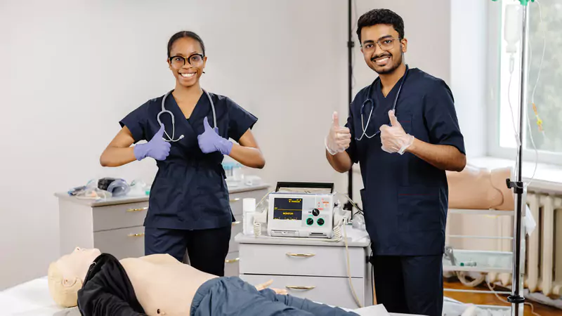 two-medical-students-giving-thumbs-up-during-cpr-training-session-on-a-mannequin