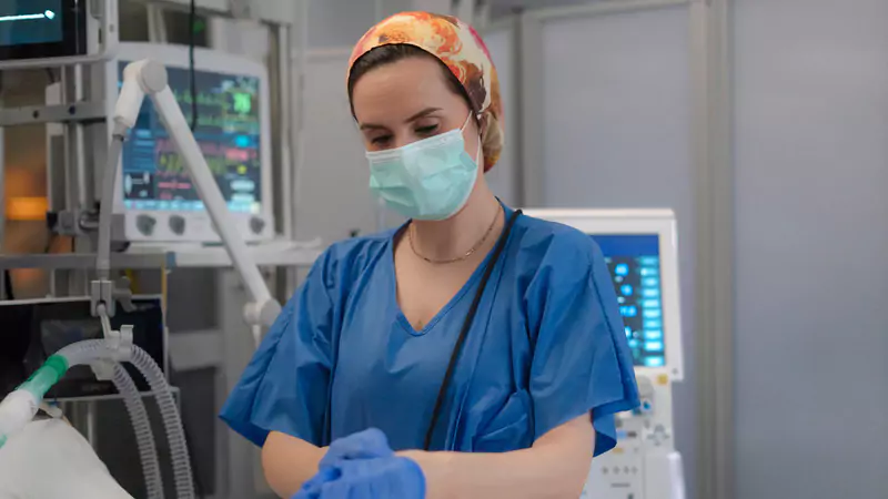 icu-nurse-in-scrubs-wearing-mask-and-gloves-in-critical-care-unit