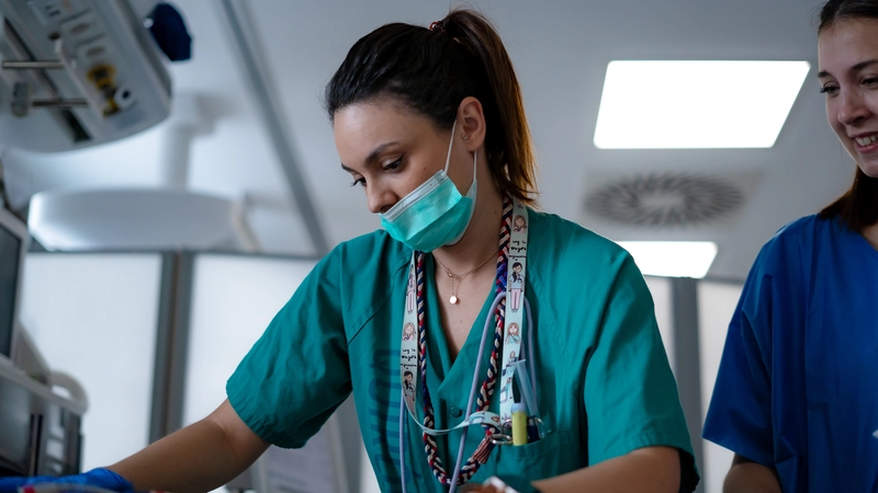 Focused nurse in green scrubs performing a medical task, symbolizing growth and future opportunities in aesthetic nursing