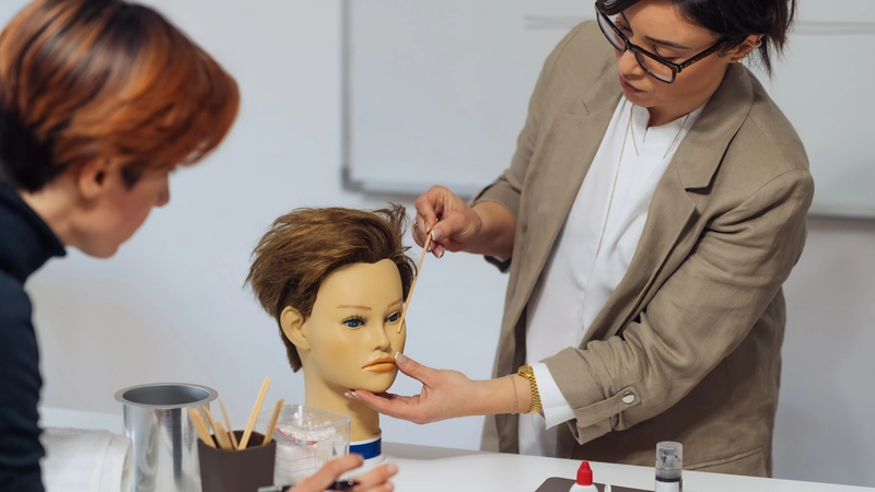Instructor demonstrating facial injection techniques on a mannequin head during an aesthetic nurse training course