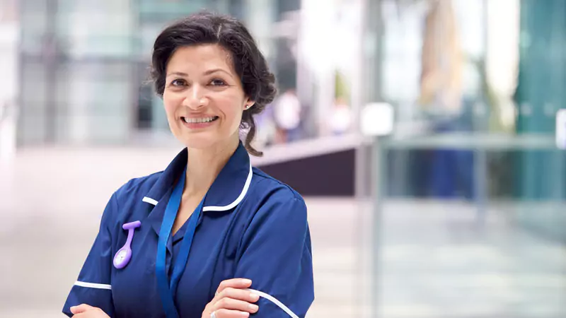confident-nurse-manager-in-uniform-smiling-in-modern-hospital-lobby