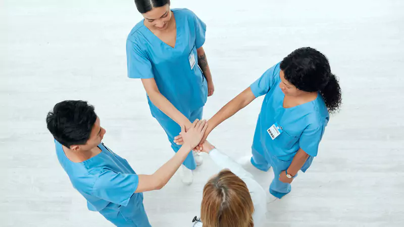 group-of-nurses-joining-hands-in-team-huddle-symbolizing-collaboration-and-mutual-support