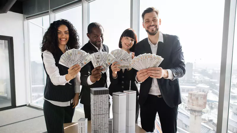 diverse-business-team-celebrating-high-earnings-with-cash