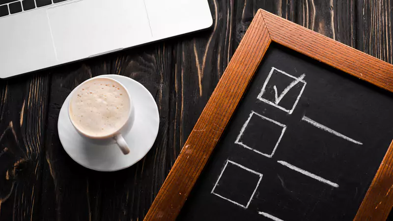 checklist-on-chalkboard-next-to-coffee-and-laptop
