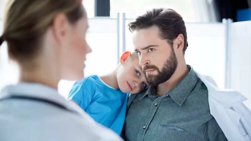 nurse-talking-to-concerned-father-holding-sick-child-demonstrating-empathy-in-difficult-situations